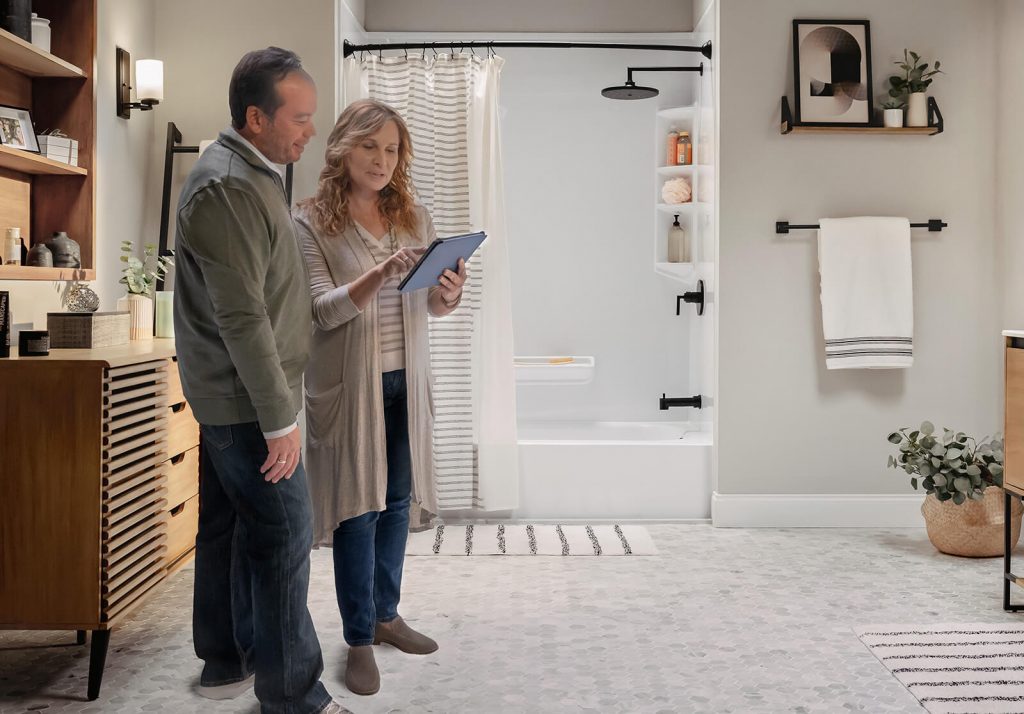 A couple browses for options on their tablet while standing in a renovated bathroom