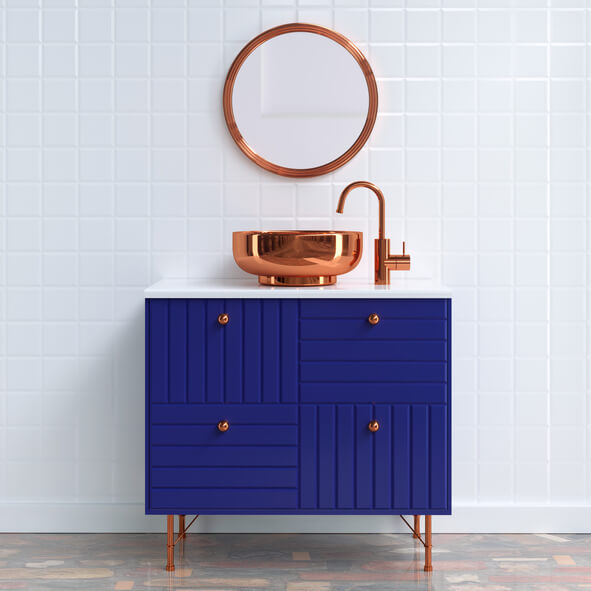 Navy blue bathroom vanity with bronze faucets and a bronze framed mirror