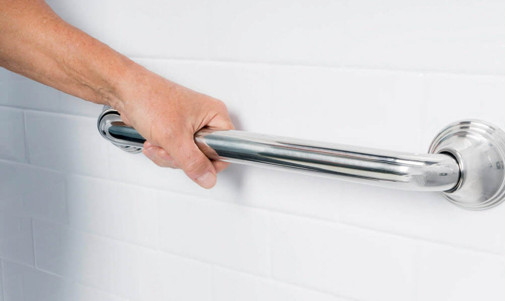 A person holding a shower grab bar