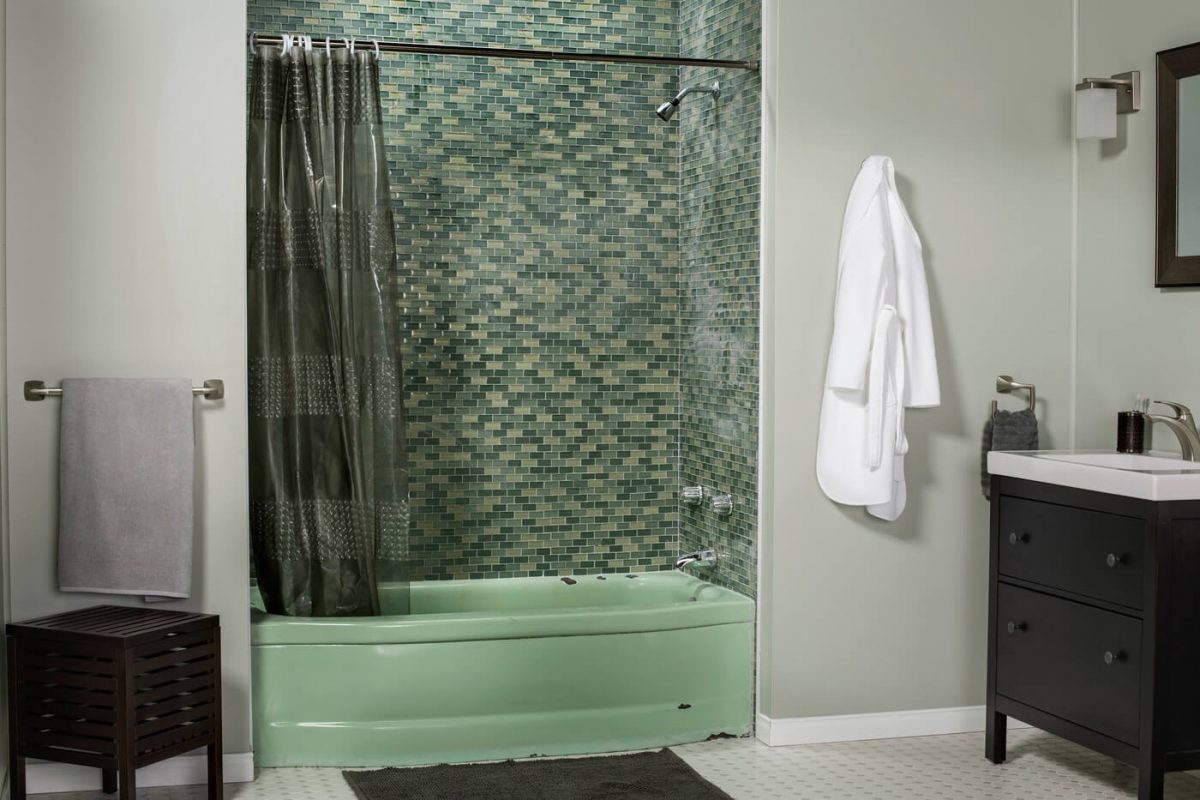 Out of style green bathtub in a grey bathroom