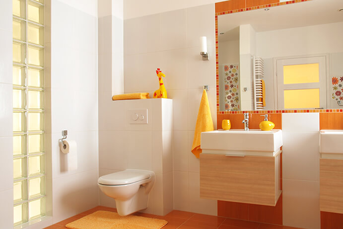 A modern child's bathroom with orange floor and wall tile