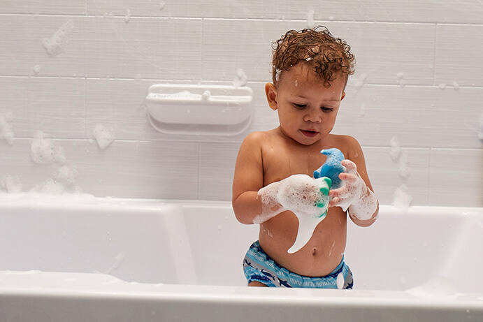 Boy in bath playing with toy 