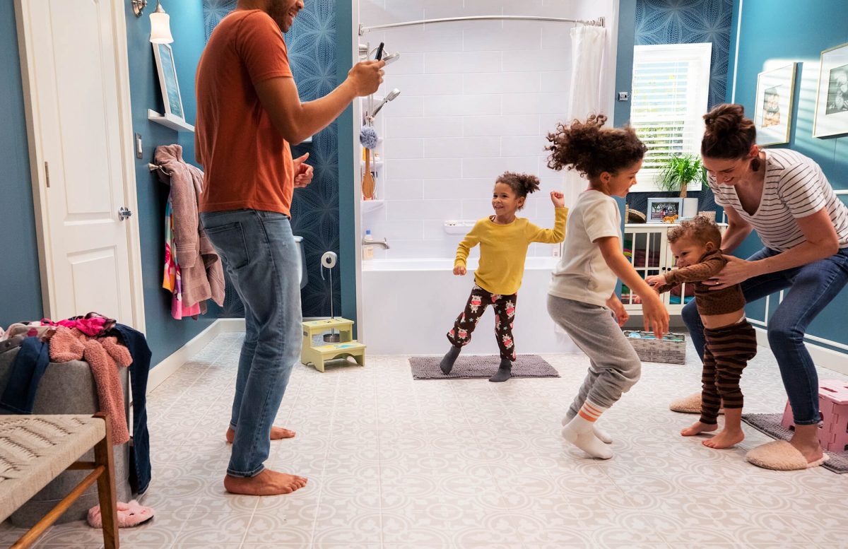 Parents and children dancing in a bright colored bathroom