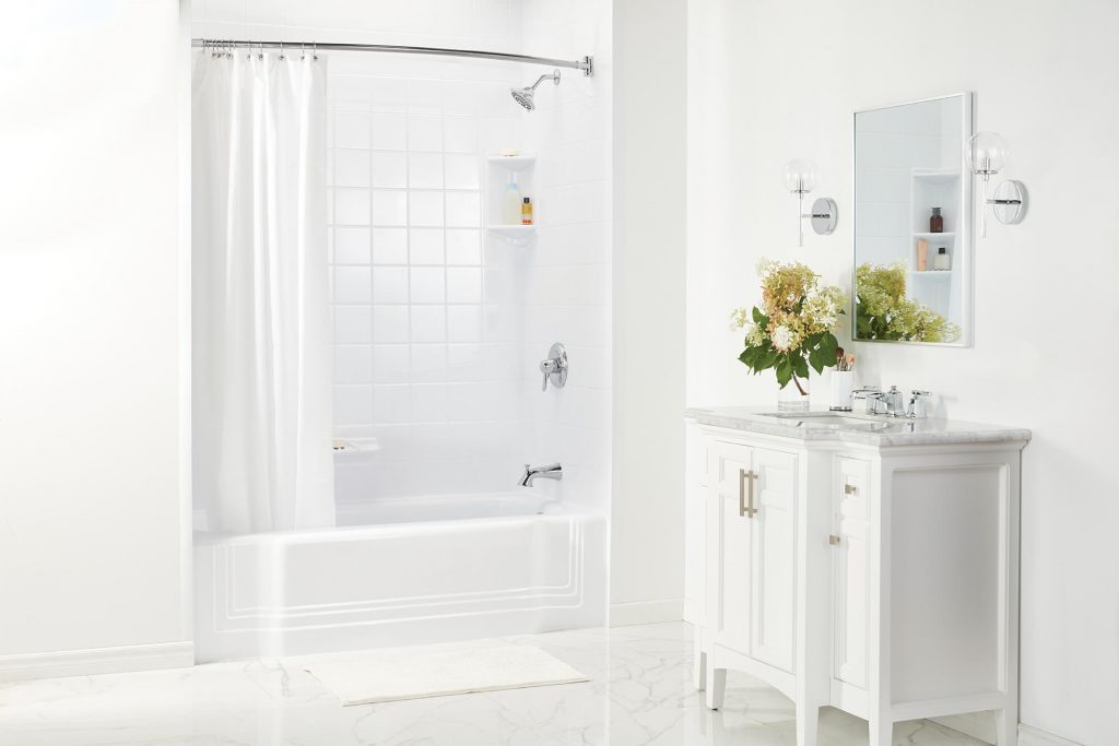 A white bathroom with free standing white vanity and a vase of flowers