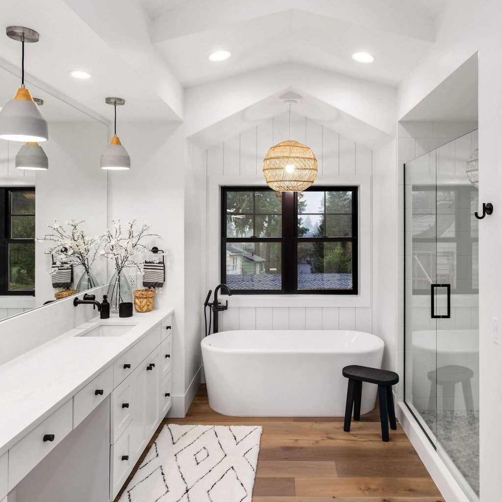 a beautiful contemporary bathroom with large soaker tub and walk in shower adorned with woven light fixture in center of room