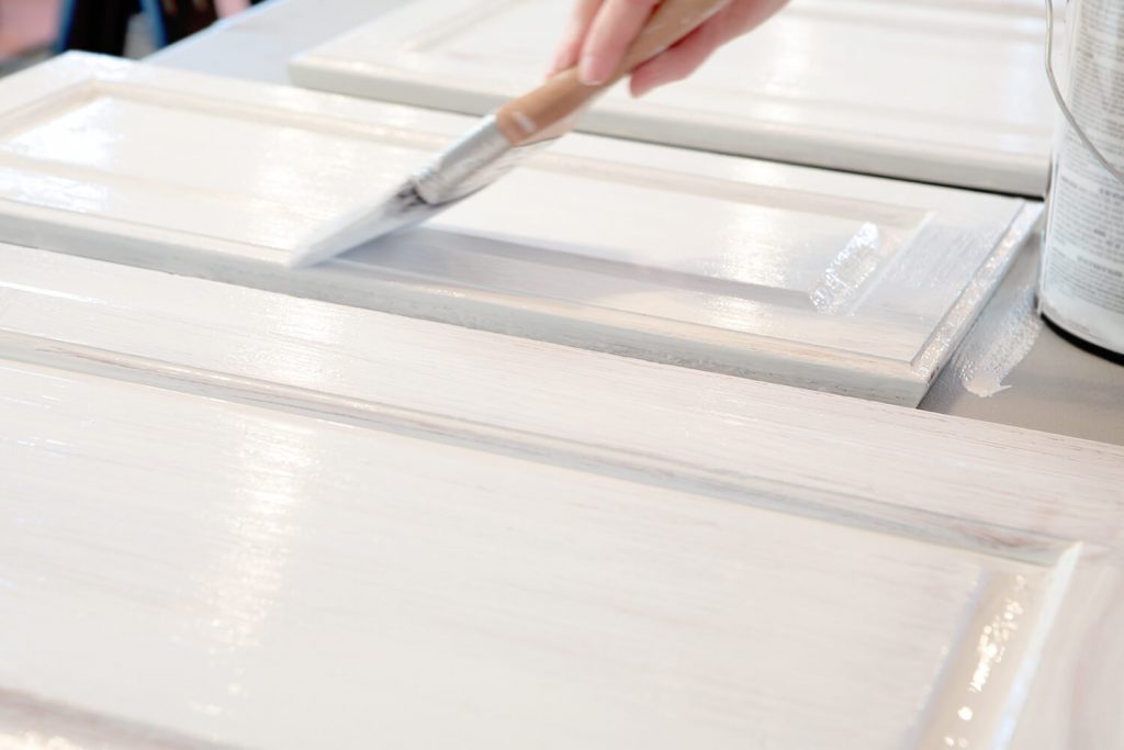 Wood cabinets are being painted a white color.