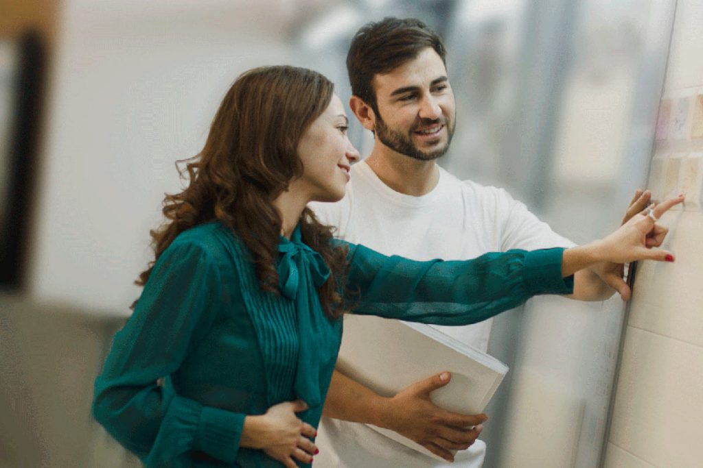 A couple is feeling different textures on a wall while shopping