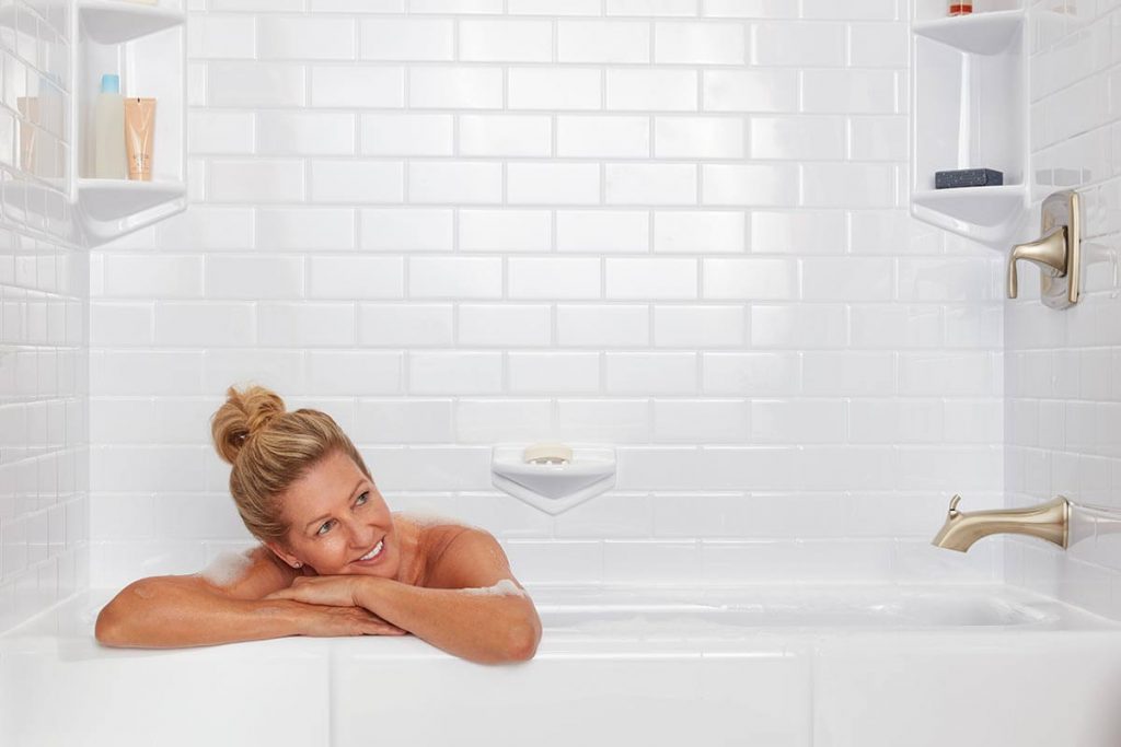 Woman smiling from her new white acrylic bathtub