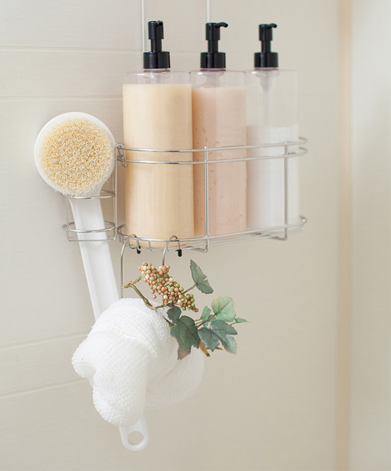 Shampoo conditioner and body soap hanging in a shower caddy.